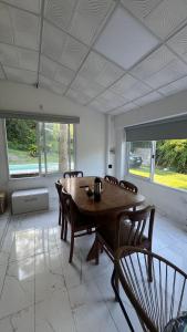 a dining room with a wooden table and chairs at Casa Quinta La Jaula in Isla Paracao