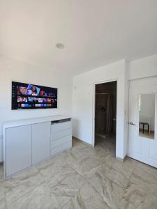 a living room with a flat screen tv on a wall at Casa Tulipanes Morelos, Alberca Climatizada, Jacuzzi y Roof in Morelos
