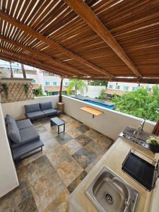 an outdoor patio with a sink and a wooden pergola at Casa Tulipanes Morelos, Alberca Climatizada, Jacuzzi y Roof in Morelos