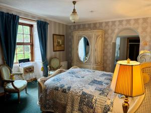 a bedroom with a bed and a lamp and a chair at Cavangarden House in Ballyshannon