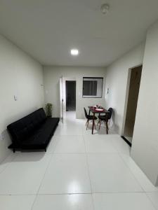 a living room with a black couch and a table at Flat Lucidata in Feira de Santana