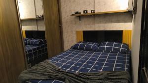 a bedroom with a bed with blue sheets and pillows at Flat São Vicente Praia Piscina Garagem in São Vicente +44 photos