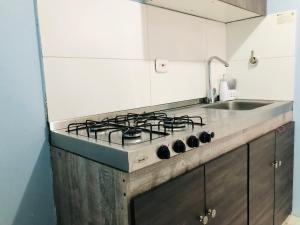 a kitchen with a stove and a sink at GV Aparta Suites Apto Familiar Amplio y Luminoso in Chía