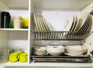 a kitchen pantry with plates and dishes on shelves at GV Aparta Suites Apto Familiar Amplio y Luminoso in Chía +23 photos