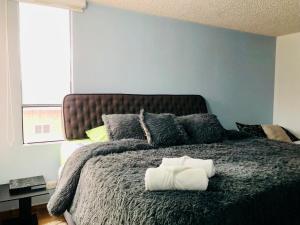 a bedroom with a bed with two towels on it at GV Aparta Suites Apto Familiar Amplio y Luminoso in Chía