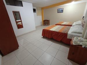 a bedroom with a bed and a tiled floor at Hotel Pradera de los Celajes in Cajamarca