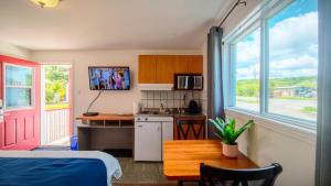 a room with a kitchen with a table and a kitchen at Motel des Pentes et Suites in Saint-Sauveur-des-Monts