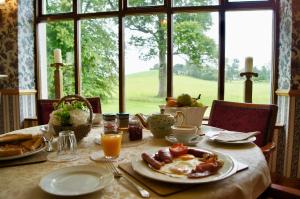 a table with breakfast food on it with a window at Cavangarden House in Ballyshannon