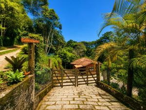 a wooden gate leading to a path in a garden at Chalé vista para Mata Itaipava in Araras Petropolis