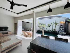 a living room with a pool and a ceiling fan at Lipah Beach Private Villas in Amed