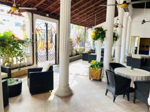 a patio with a table and chairs and a fence at Encanto Hotel Boutique in Santa Marta