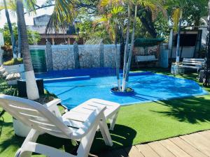 a pair of white chairs next to a swimming pool at Encanto Hotel Boutique in Santa Marta