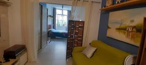 a living room with a green couch and a bedroom at Angel's House Flamengo RJ in Rio de Janeiro