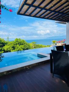 a swimming pool with a view of the ocean at Villa Amihan in Puerto Galera