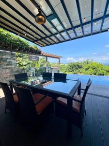 a table and chairs on a deck with a view at Villa Amihan in Puerto Galera