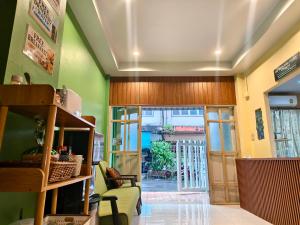 a living room with green walls and a couch at Happy Homey Hostel in Suratthani
