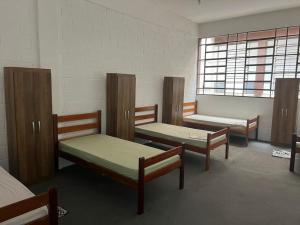 a room with three bunk beds and a window at Pousada Fortaleza SP 8 in São Paulo