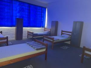 a room with three beds and a window at Pousada Fortaleza SP 8 in São Paulo
