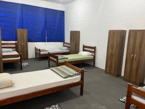a room with several beds and wooden cabinets at Pousada Fortaleza SP 8 in São Paulo