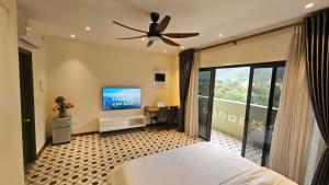 a bedroom with a bed and a flat screen tv at Sonasea Vân Đồn - Centraltique Seaside in Quang Ninh