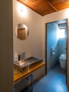 a bathroom with a sink and a mirror and a toilet at 汐見屋 in Tanabe +21 photos