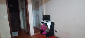 a room with a desk with a television on it at Assel Pousada Xaxim in Curitiba