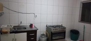 a kitchen with a stove and a sink at Assel Pousada Xaxim in Curitiba