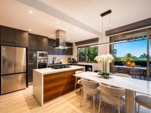 a kitchen with stainless steel appliances and a table with chairs at Casa Vista 133 in Cabo San Lucas