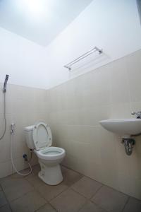 a bathroom with a toilet and a sink at The Villa Tembalang in Srondolwetan