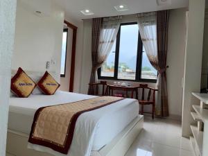 a bedroom with a bed and a table and windows at Anh Duong in Lục Yên +46 photos