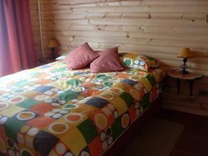 a bed with a colorful comforter in a bedroom at Eco Cabañas Algarrobo in Algarrobo