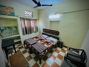 a room with a bed and a table and chairs at Gaurav Guest House in Mathura