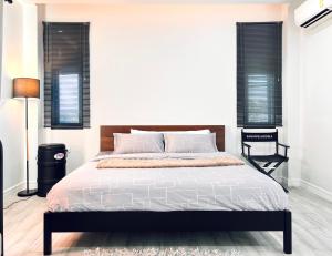 a bedroom with a large bed and two windows at LECAR Home Shelby in Ban Nong Khang