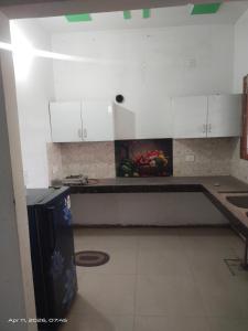 a kitchen with white cabinets and a bowl of fruit at AC Room Double Bed 1st floor House in Mohali