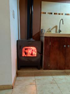 a kitchen with a stove in a room with a sink at Cabañas Pucara Taki in Tilcara