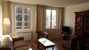 a living room with a couch and two windows at Les appartements Place de la Cathédrale in Strasbourg