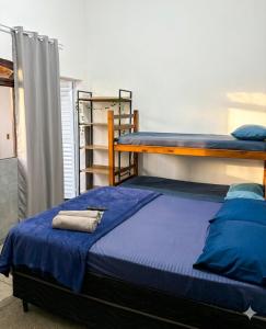 a bedroom with two bunk beds with blue sheets at Pousada Ocean Próx Sesc Bertioga - Beira Mar in Bertioga