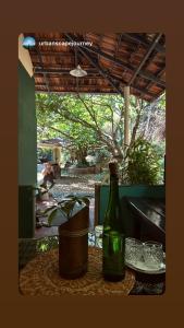 a bottle of wine sitting on a table with a plant at Mass Bungalow in Tindummal