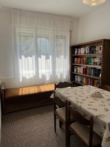 a bedroom with a bed and a window and a table at Katalin vendégház felső szint in Visegrád