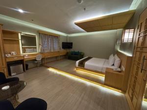ein Hotelzimmer mit Bett und Fernseher in der Unterkunft UNUMA HOTEL in Jakarta