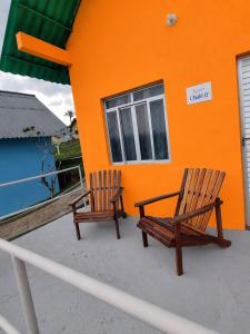 two wooden chairs sitting in front of a building at ECO CHALÉ PARK CACHOEIRAS in Presidente Figueiredo