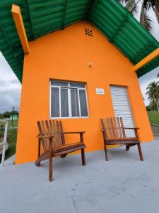 two wooden chairs in front of a house at ECO CHALÉ PARK CACHOEIRAS in Presidente Figueiredo +83 photos
