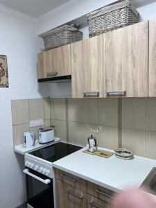 a kitchen with wooden cabinets and a stove top oven at Katalin vendégház felső szint in Visegrád