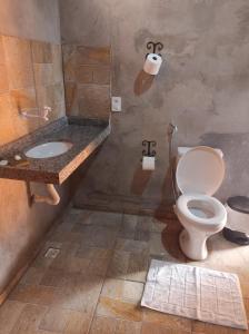 a bathroom with a toilet and a sink at Chale Tupi da Pedra in Trindade