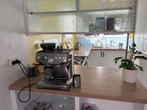 a kitchen with a coffee maker on a counter at Cute Chartwell Cottage in Hamilton +3 photos