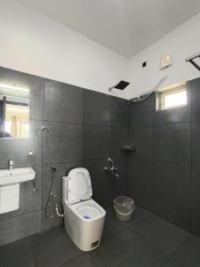a bathroom with a toilet and a sink at Adithya resort vagamon in Vagamon +24 photos
