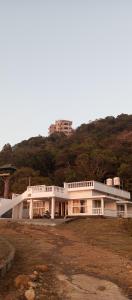 a large white building on top of a hill at Adithya resort vagamon in Vagamon