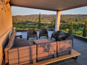 a porch with a couch and chairs on a balcony at TAKAMAKA in Manosque
