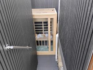 a door leading into a room with a small cabinet at Romantic Ocean View Studio at Stanwell Tops in Stanwell Park