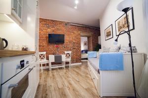 a room with a bed and a brick wall at Apartamenty Pocztowa in Bydgoszcz